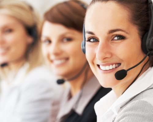 Closeup of customer service representative with colleagues in background